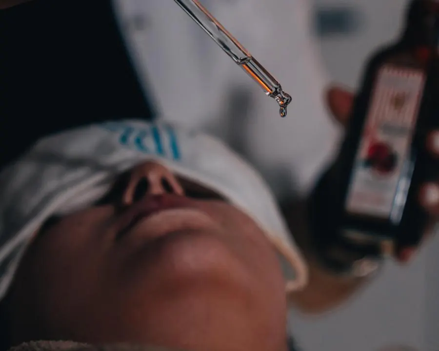 Profesyonel cilt bakımı sırasında yüze damlalıkla serum uygulanması