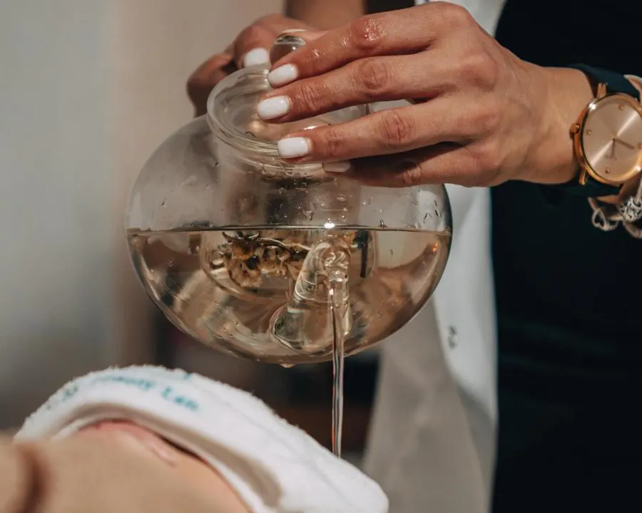 BIOSCHA Beauty Lab'da Head Spa ritüeli sırasında cam demlikten saçlara ılık su dökülmesi